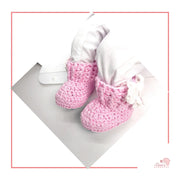 Image is a pair of crochet pink baby shoes with a white bow and authentic African Ankara  fabric on the soles. Perfect for keeping baby stylish, comfortable and representing culture.