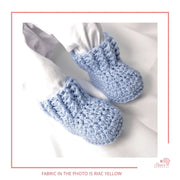 Image is a pair of crochet light blue baby shoes with a white bow and authentic African Ankara  fabric on the soles. Perfect for keeping baby stylish, comfortable and representing culture.