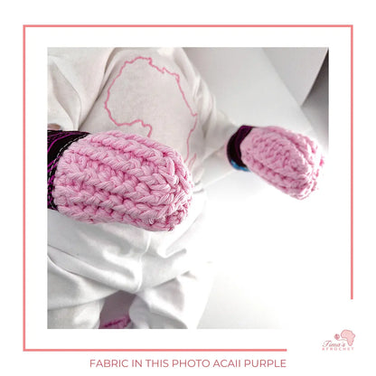 Image is a pair of crochet pink baby mittens with authentic African Ankara fabric on the rim where the wrists is.Perfect for keeping baby stylish, comfortable and representing culture. 