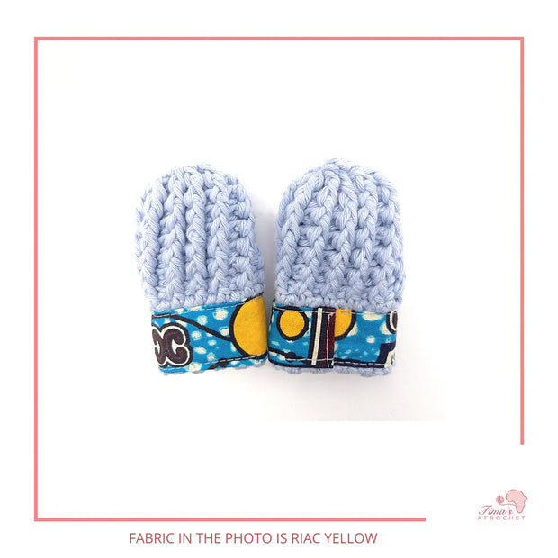 Image is a pair of crochet light blue baby mittens with authentic African Ankara fabric on the rim where the wrists is.Perfect for keeping baby stylish, comfortable and representing culture. 