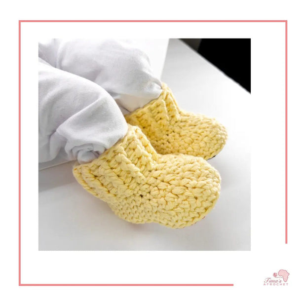 Image is a pair of crochet light yellow baby shoes with a white bow and authentic African Ankara  fabric on the soles. Perfect for keeping baby stylish, comfortable and representing culture.