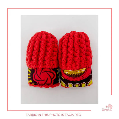 Image is a pair of crochet red baby mittens with authentic African Ankara fabric on the rim where the wrists is.Perfect for keeping baby stylish, comfortable and representing culture. 